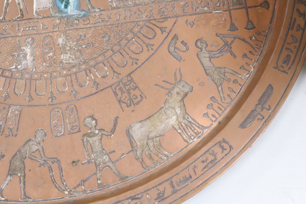 A large circular copper tray with white metal inlay depicting ancient Egyptian scenes, diameter 61cm